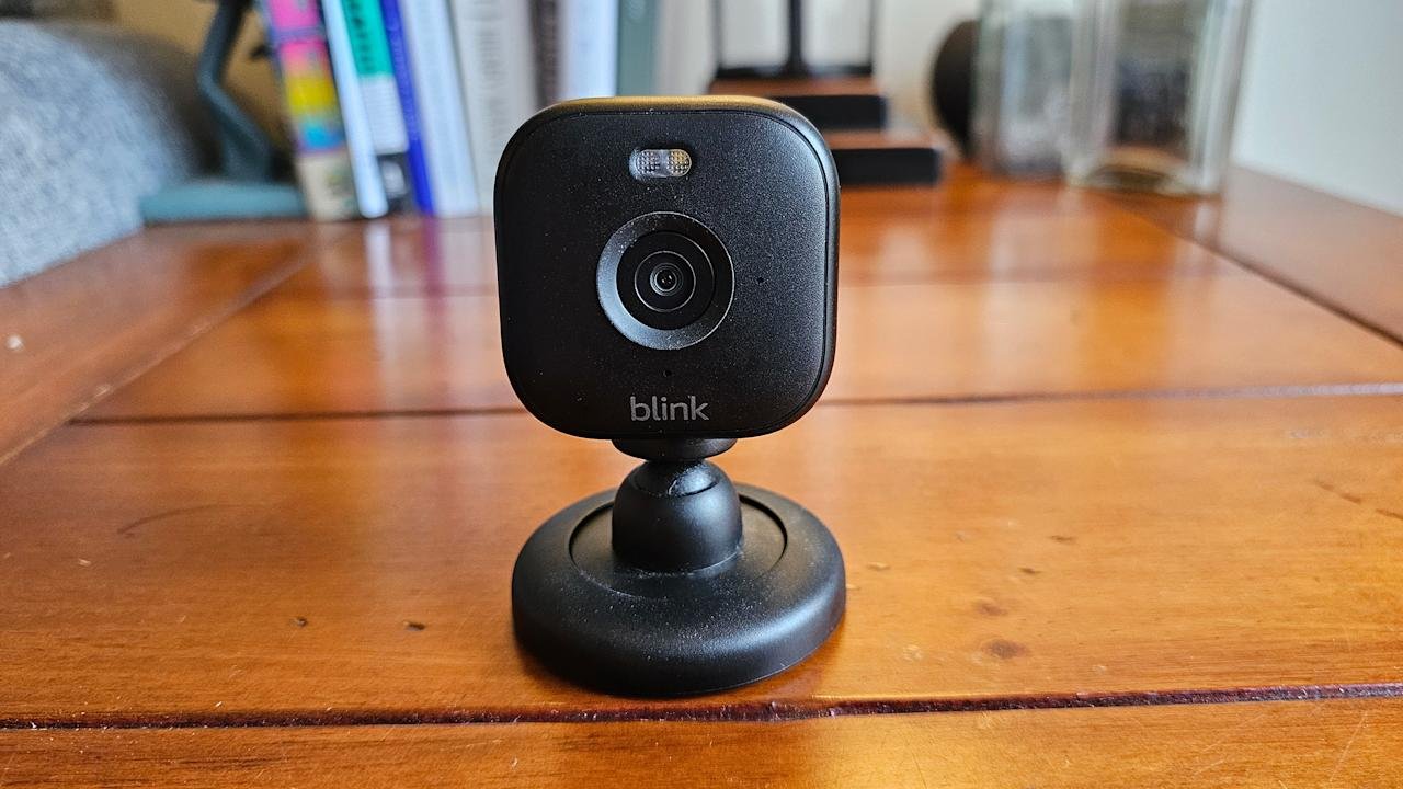 O Blink Mini 2 está localizado em uma mesa de madeira marrom.