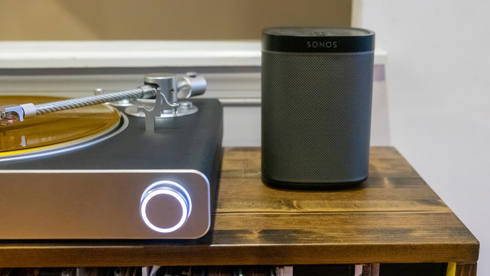 Victrrola Stream Carbono Durtable sentado em uma prateleira ao lado do Sonos Speoker.